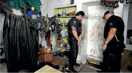  ?? PHOTOS: REUTERS ?? Police officers examine the entrance to a 500-metre tunnel leading from a house to the main vault of the Bank of Brazil in Sao Paulo.