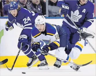  ?? FRANK GUNN THE CANADIAN PRESS ?? Maple Leafs right-winger Kasperi Kapanen (24) looks to scoop the puck as St. Louis Blues left-wingerZach Sanford (12) hits the ice during NHL action in Toronto on Saturday night. The Leafs lost the game, 4-1.