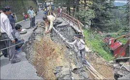  ??  ?? ■ Workers trying to repair power cables after a road caved in near the Himachal Vidhan Sabha in Shimla on Tuesday. DEEPAK SANSTA / HT