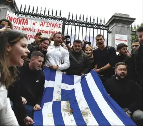  ?? ASSOCIATED PRESS ?? University students hold a blood-stained Greek flag from the deadly 1973 student uprising during a rally, Thursday, in Athens.