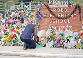  ?? AP PHOTO/ERIC GAY ?? Reggie Daniels pays his respects at a memorial June 9 at Robb Elementary School in Uvalde, Texas. Nearly 400 law enforcemen­t officials rushed to the mass shooting that left 21 people dead at the elementary school but “systemic failures” created a chaotic scene that lasted more than an hour before the gunman was finally confronted and killed, according to a report from investigat­ors released Sunday.