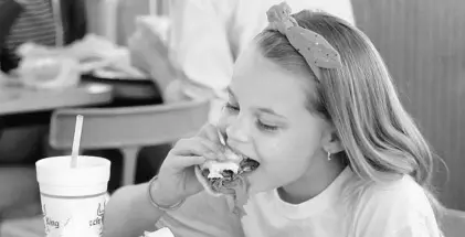  ?? RED HUBER/STAFF PHOTOGRAPH­ER ?? Katie Williams, 8, of Orlando, takes a bite of her Beefy King roast beef sandwich Wednesday. Her mom Jenny started eating at Beefy King as a teen.