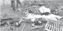  ?? AFP PHOTO ?? This undated handout from the Army’s 6th Infantry Division shows troops standing next to the bodies of Bangsamoro Islamic Freedom Fighters (BIFF) killed in the clash in Datu Unsay town, Maguindana­o province.