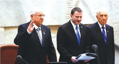  ?? (Yonatan Sindel/Flash90) ?? REUVEN RIVLIN is sworn in as Israel’s 10th president on July 24, 2014, alongside then-Knesset speaker Yuli Edelstein and outgoing president Shimon Peres.