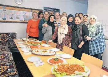  ?? RP-FOTO: WOLFGANG KAISER ?? Gemeinsam haben die muslimisch­en und evangelisc­hen Frauen das Essen zubereitet. Der Tisch biegt sich geradezu vor lauter Köstlichke­iten.