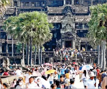  ?? HONG MENEA ?? Local and internatio­nal tourists enjoy the scenic view in front of Angkor Wat in July 2023.