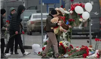  ?? ?? Des personnes déposent des fleurs et des jouets devant le Crocus City Hall, à l'ouest de Moscou, en Russie, le samedi 23 mars 2024.