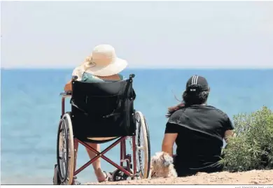  ?? KAI FORSTERLIN­G / EFE ?? Una mujer en silla de ruedas contempla el mar acompañada.
