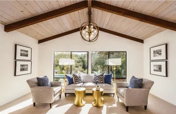  ?? OLGA SOBOLEVA ?? Above: Sizable sitting area with verdant views in the primary bedroom. Below left: The entry showcases modernist design, original pendants and a wall of windows that frame the outdoors. Below right: Large covered patio and the yard beyond is accessed from the inside for a seamless indoor/outdoor lifestyle.