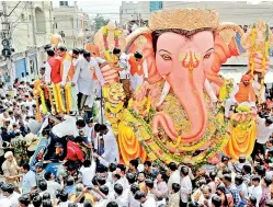  ?? — P. SURENDRA ?? Devotees take the idol of Balapur Lord Ganesha for immersion on the last day of Ganesh festival celebratio­ns. (Right) Devotees bring out a big procession from Charminar to Tank Bund.