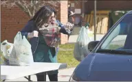  ?? H John Voorhees III / Hearst Connecticu­t Media ?? Volunteer Bianca Perrone Bethel helps distribute lunch and breakfast bags at Berry School on Wednesday morning in Bethel.