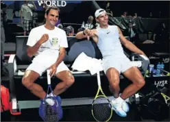  ??  ?? BROMAS. Nadal, con el pulgar hacia abajo, bromea con Federer.