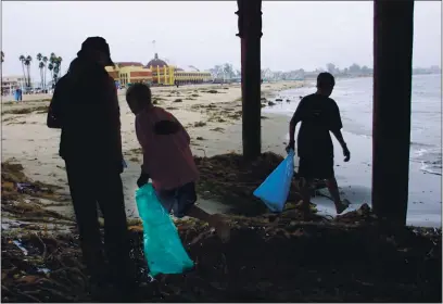  ?? JUDITH CALSON — BAY AREA NEWS GROUP FILE ?? Scotts Valley residents, Judy Stevens with her son Dane Stevens, age 11, and his friend Jordan Toccalino, age 11, are picking up trash under the Santa Cruz Wharf in Santa Cruz in 2001. For the first time in the 36-year history of Coastal Cleanup Day there will be no organized groups handing people bags and helping them record what they found on the third Saturday of September. Instead, the California Coastal Commission, which organizes the event every year, is asking people to fly solo.