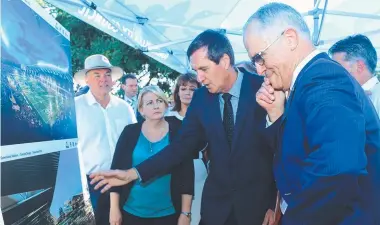  ?? MERE ONLOOKER: Coralee O'Rourke with other politician­s, including Mayor Jenny Hill and the Minister for State Developmen­t Dr Anthony Lynham, show Prime Minister Malcolm Turnbull the new Townsville Stadium plans. ??