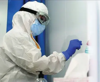  ??  ?? Una sanitaria realiza un test rápidos de antígenos a una mujer