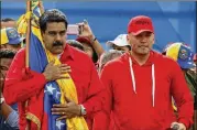  ?? ARIANA CUBILLOS / ASSOCIATED PRESS ?? Venezuelan President Nicolas Maduro (left) holds the Venezuelan flag while standing next to singer “El Potro Alvarez” during a rally in Caracas, Venezuela, on Thursday.