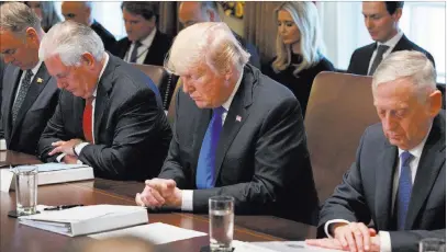  ?? Evan Vucci ?? The Associated Press President Donald Trump prays during a Cabinet meeting Wednesday at the White House. From left are Secretary of the Interior Ryan Zinke, Secretary of State Rex Tillerson, Trump, and Secretary of Defense Jim Mattis.