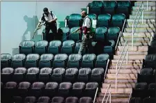  ?? CHARLIE RIEDEL/AP PHOTO ?? Workers sprays disinfecta­nt on seats to prevent the spread of COVID-19 at the T-Mobile Center between sessions at the Big 12 Conference tournament on Thursday in Kansas City, Mo.