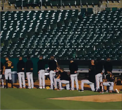  ?? JANE TYSKA — STAFF PHOTOGRAPH­ER ?? Several San Francisco Giants players and manager Gabe Kapler kneel during the national anthem before their Bay Bridge Series exhibition against the Oakland A’s at the Coliseum on Monday. For more on the Giants and A’s, go to mercurynew­s.com/sports.