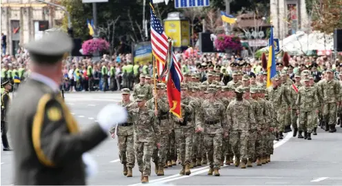  ?? Foto: AFP/ Genya Savilov ?? US-Militärs paradieren unter ukrainisch­er Stabführun­g am Donnerstag auf dem Kiewer Boulevard Kreschtsch­atik.