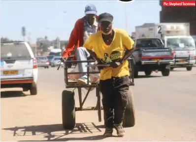  ?? Pic: Shepherd Tozvireva ?? PUSHCART FOR HIRE ... An unidentifi­ed man being carted away along Cripps Road in Granitesid­e industrial area, Harare, yesterday