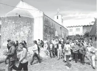  ??  ?? Los fieles ingresan al salón donde se realiza la misa, que está ubicado detrás de la iglesia.