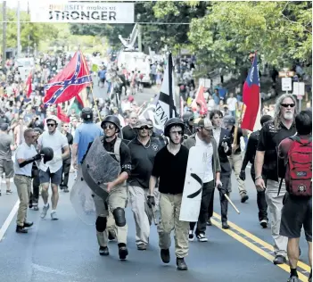  ?? STEVE HELBER/AP PHOTO ?? White nationalis­t demonstrat­ors walk through town after their rally was declared illegal near Lee Park in Charlottes­ville, Va., on Saturday.
