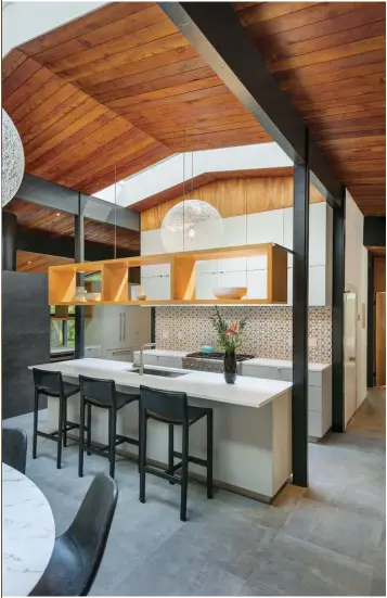  ??  ?? (ABOVE) KITCHEN RENOVATION­S INCLUDED REMOVING A WALL THAT SEPARATED THE KITCHEN FROM THE DINING ROOM WHERE THE OPEN SHELVING UNIT IS. THIS CREATED A MORE FUNCTIONAL LIVING AREA FOR THE HOMEOWNERS.