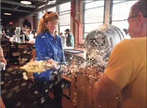  ?? Brian A. Pounds / Hearst Connecticu­t Media ?? Beer flies through the air as Stratford Mayor Laura Hoydick taps a keg of Herzzoner, the company’s seasonal Maibock beer, with the help of company founder and CEO Brad Hittle at Two Roads Brewing Company in Stratford on Thursday.