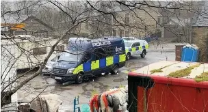  ??  ?? ● Police at the ‘mighty suspicious’ scene on Shaw Clough Road, Waterfoot