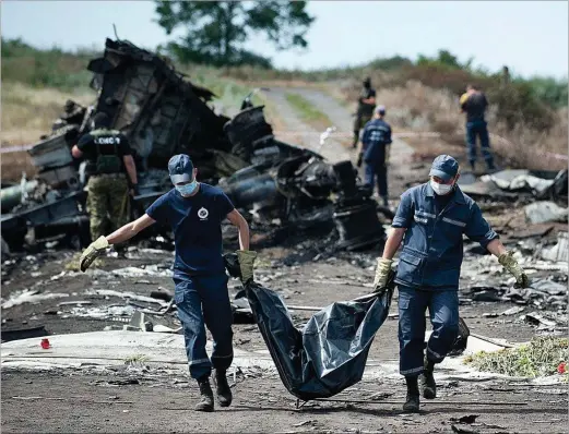  ?? EVGENITY MALOLETKA / AP ?? Los servicios de emergencia de Ucrania trasladan el cadáver de una víctima del avión MH17, cerca del pueblo de Grábovo (este de Ucrania).