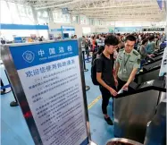  ??  ?? 16 de junio de 2018. Un policía civil ayuda a un viajero a hacer el check in en una máquina del aeropuerto de Qingdao, provincia de Shandong. Cnsphoto