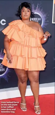  ??  ?? Lizzo looked fierce on the red carpet in her ruffled neon dress and Valentino bag.