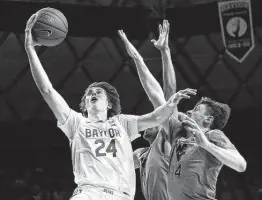  ?? Ronald Martinez / Getty Images ?? Baylor’s Matthew Mayer, right, goes up for a shot against Chase Harler of West Virginia during the second half at Ferrell Center in Waco on Saturday.