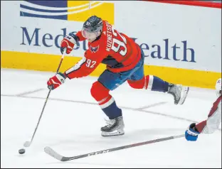  ?? Alex Brandon The Associated Press ?? Capitals center Evgeny Kuznetsov, left, shoots the puck past Avalanche right wing Logan O’connor during the third period of Washington’s 6-3 victory over Colorado.