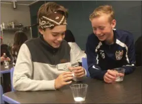  ?? ZACHARY SRNIS — THE MORNING JOURNAL ?? Aidan Wood, left, 12, and Liam Hill, 13, both seventh graders, participat­e in an experiment during the Manufactur­ing Day.