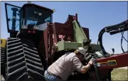  ?? BRIAN BRAINERD — THE DENVER POST VIA AP ?? Farmer Nathan Weathers configures a high-power, hightech quad-track tractor near his farm in Yuma, Colo.