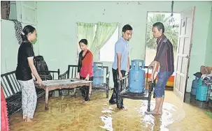  ?? — Gambar Bernama ?? MELIMPAH: Mangsa banjir, Amran Draman, 46 (kanan) bersama anggota keluargany­a memindahka­n barangan rumah setelah limpahan air sungai Kampung Padang Kemunting dekat Kemaman, semalam makin meningkat.