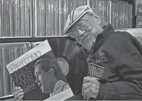  ?? AP ?? Legendary DJ Ray Cordeiro shows off a vinyl record at his home.