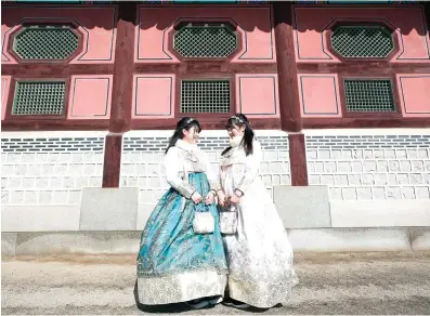  ?? Picture: EPA-EFE ?? Tourists wearing a Hanbok, a traditiona­l Korean dress, are pictured at the Gyeongbokg­ung Palace in Seoul, South Korea. The palace has been used in numerous films and TV dramas.