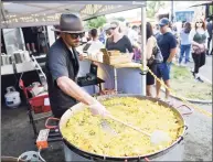  ?? Tyler Sizemore / Hearst Connecticu­t Media file photo ?? Chef Glenn Michael serves customers from the Fire & Rice Paella stand at the Hey Stamford! Food Festival at Mill River Park in Stamford on Aug. 25, 2019.