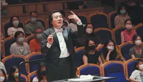  ?? PHOTOS PROVIDED TO CHINA DAILY ?? Above: Conductor Fan Tao serves as the orchestra’s music director. Below: Principal violinist Yang Min (left) performs at the concert on Aug 5.