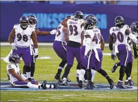  ?? Wade Payne Associated Press ?? RAVENS sit and stand on the Titans’ logo at midfield, drawing a penalty, after Baltimore cornerback Marcus Peters intercepte­d a pass late in the fourth quarter.