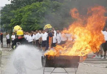  ?? (PNA) ?? Firemen on Wednesday (Dec. 28, 2016) conduct a fire drill at the Senate grounds in Pasay City. A fireman shows how to safely operate a portable fire extinguish­er on real training fires.