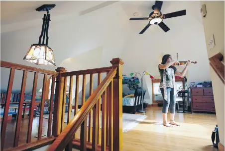  ??  ?? Margaret Durant practises her violin in her attic bedroom on the third floor of a 1909 Craftsman.