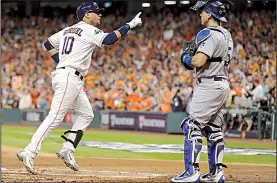  ?? AP/MATT SLOCUM ?? Houston’s Yuli Gurriel (left) points to the crowd as he crosses home plate after hitting a home run in the second inning of the Astros’ 5-3 victory over the Los Angeles Dodgers on Friday at Minute Maid Park in Houston.