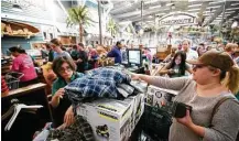  ?? Houston Chronicle file ?? Maria Villarreal checks out Black Friday items at the Bass Pro Shops in Pearland. Holiday spending is projected to rise this year.