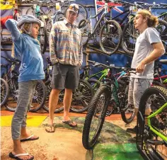  ??  ?? Jon Eybers, centre, and his daughter Brooke Eybers, 10, get some help in making a selection from University Bicycles sales associate Josh Kuntz.