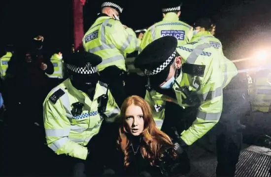 ?? HANNAH MCKAY / REUTERS ?? Detenció d’una manifestan­t la nit de dissabte en les protestes que van tenir lloc a Londres arran de l’assassinat d’una jove