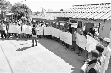  ??  ?? Thai villagers hold a peaceful demonstrat­ion against Thai military for the closure of the six boat jetties across Sungai Golok. — Bernama photo